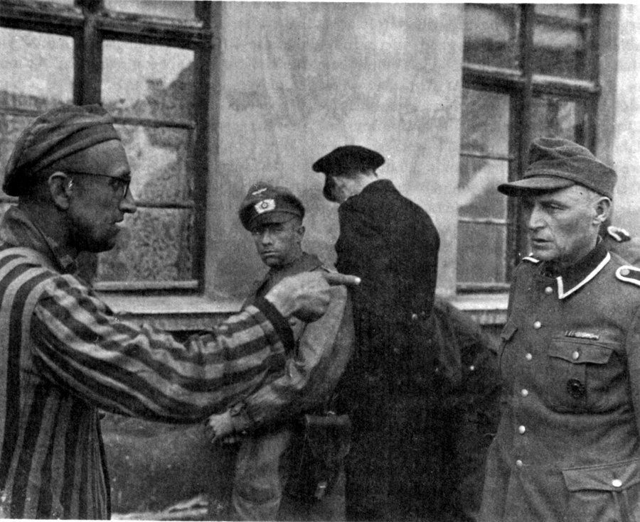 Ocalony więzień Buchenwaldu wytyka palcem strażnika z niemieckiej formacji SS, który znęcał się nad ludźmi w obozie, fot. wikipedia